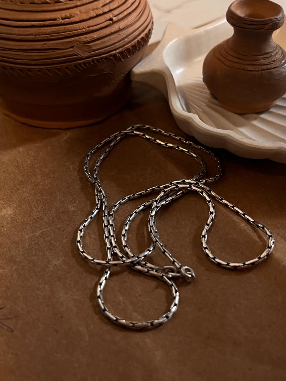 Timeless antique-patterned silver chain for an elegant look.