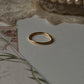 Gold vermeil plain round stack band ring placed on soft fabric with floral stationery.