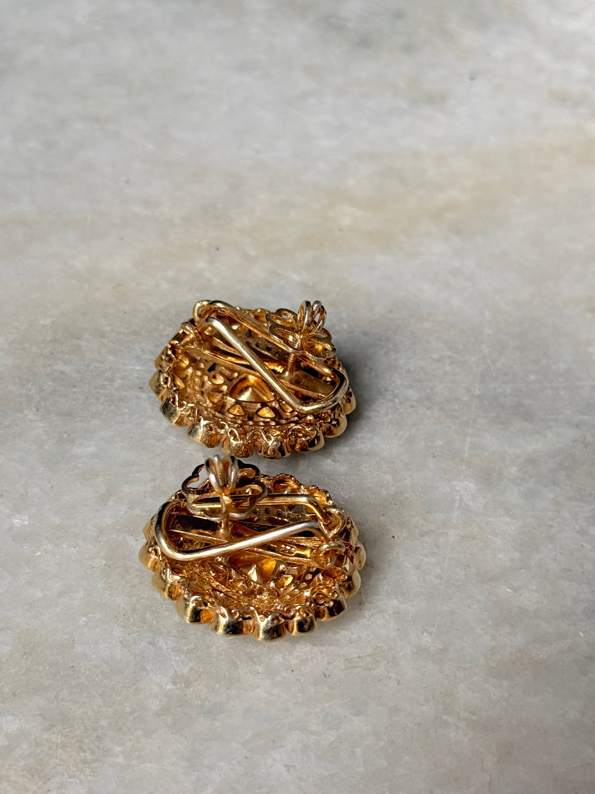 Close-up of 925 Sterling Silver Gold Plated Antique Moissanite Polki Round Studs Earrings on marble surface.