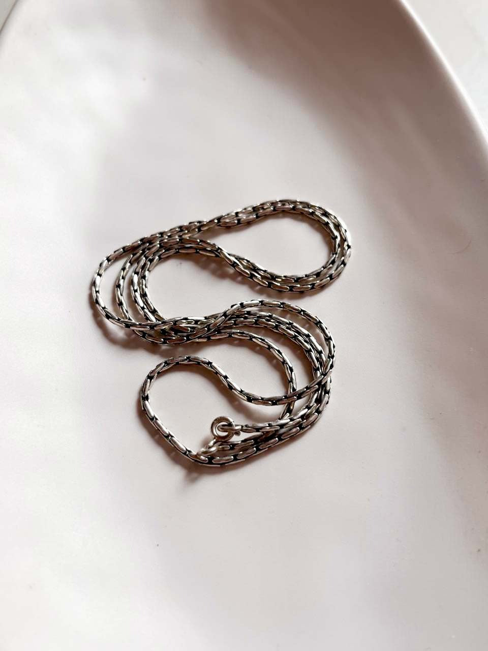 Vintage-style silver chain featuring an antique patterned design.