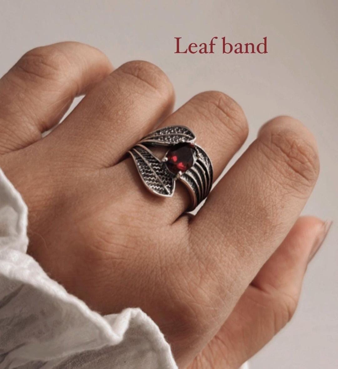 Delicate silver ring with garnet and a twisting leaf wrap design