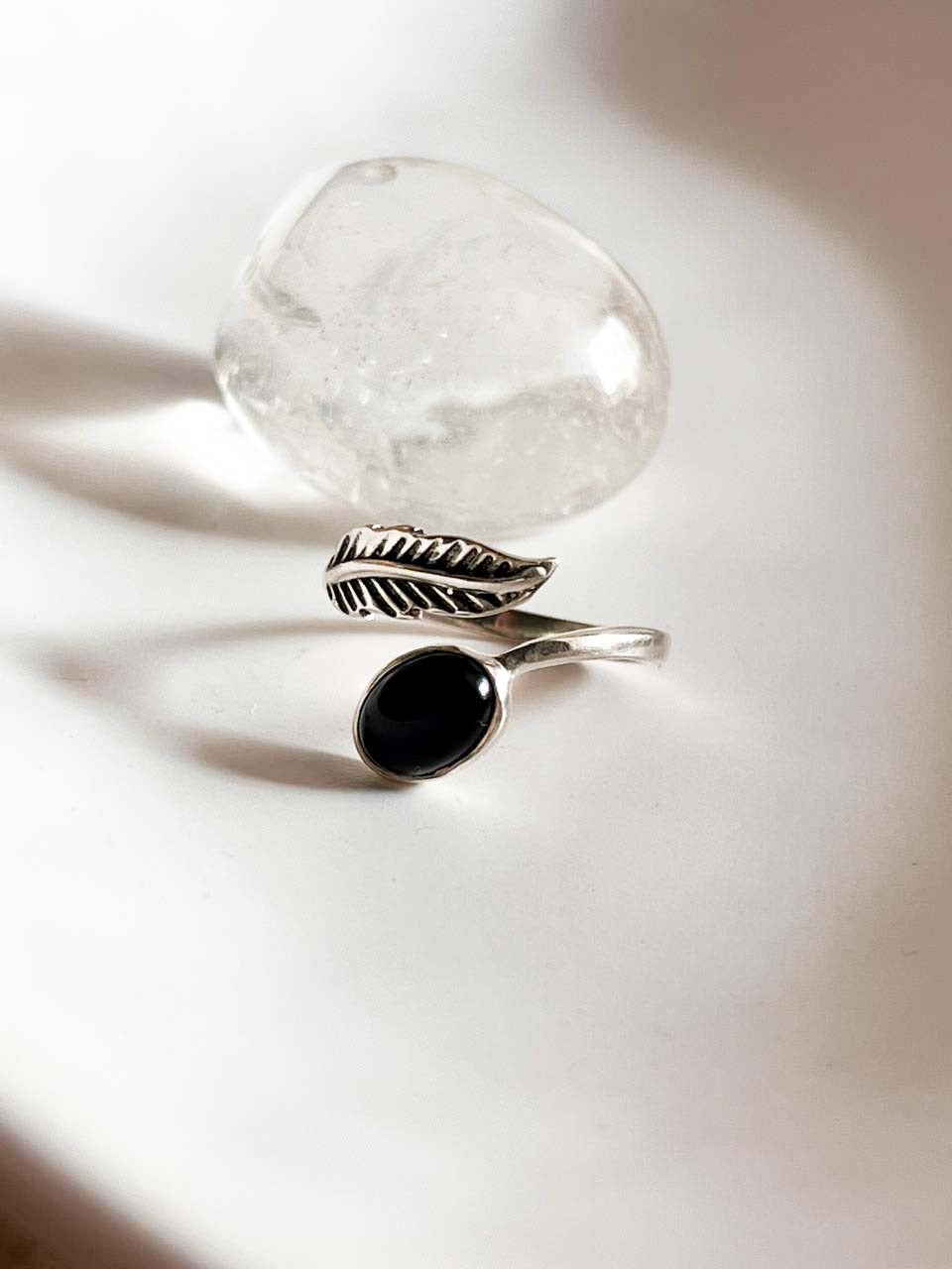 Elegant black onyx feather adjustable silver ring with intricate design.