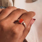 Close-up of carnelian rectangular gemstone in a silver ring