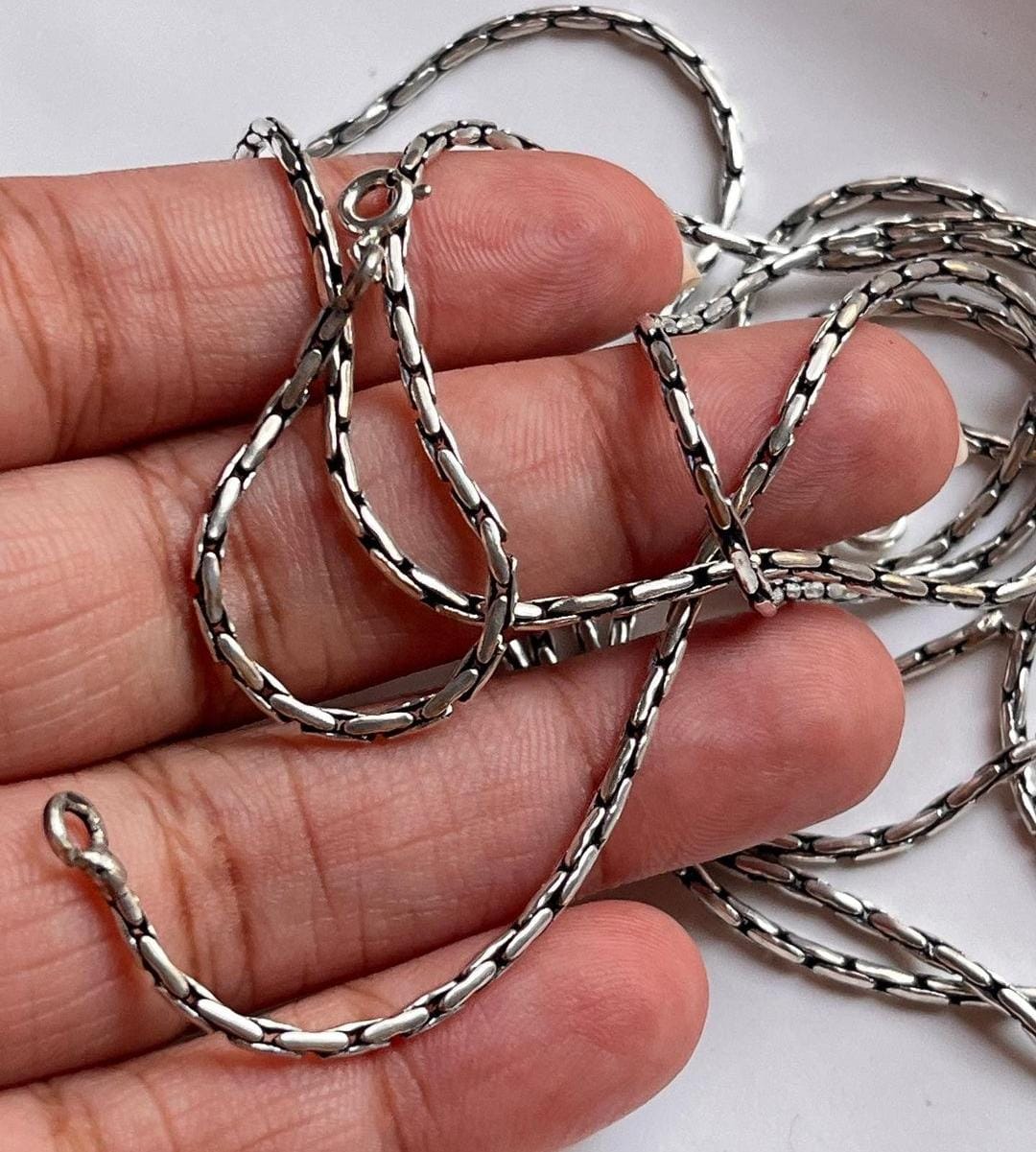 Sterling silver chain with an intricate antique pattern.