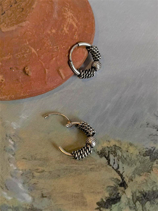 Elegant antique silver hoop earrings with intricate design.