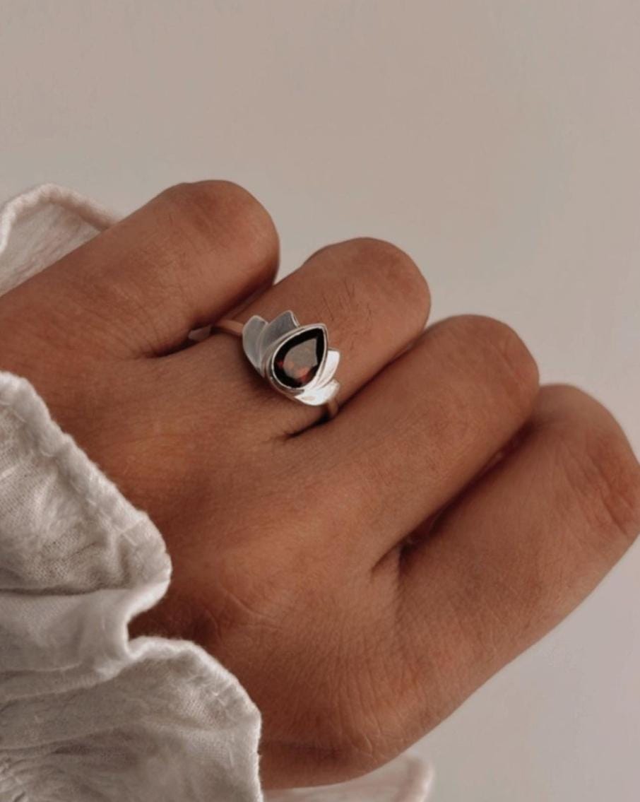 Silver ring featuring a divine lotus design and garnet stone