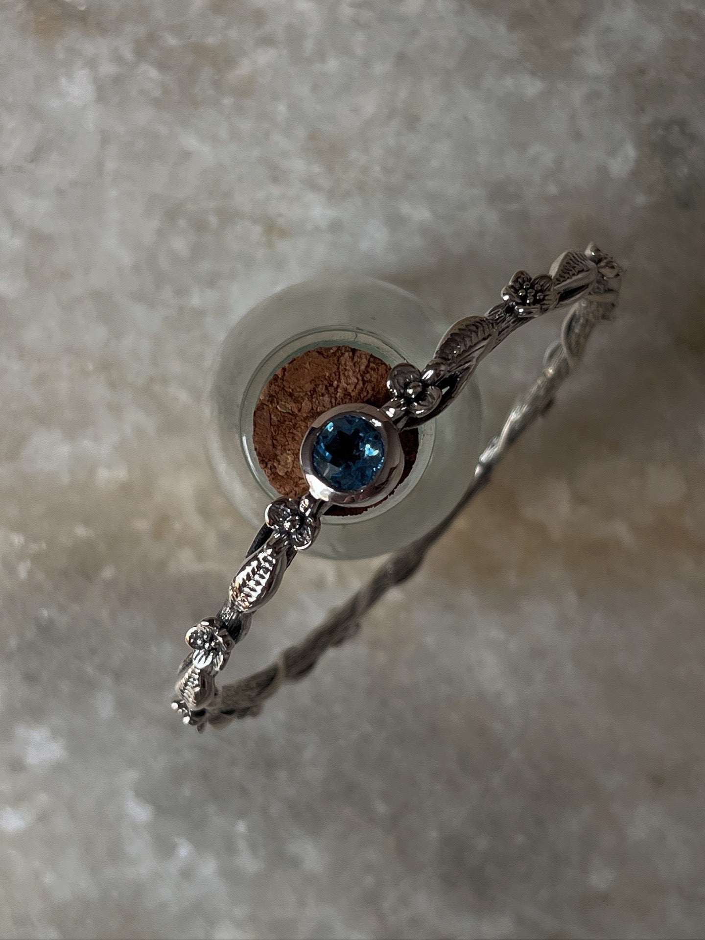 Decorative forest-inspired bangle with blue topaz in silver
