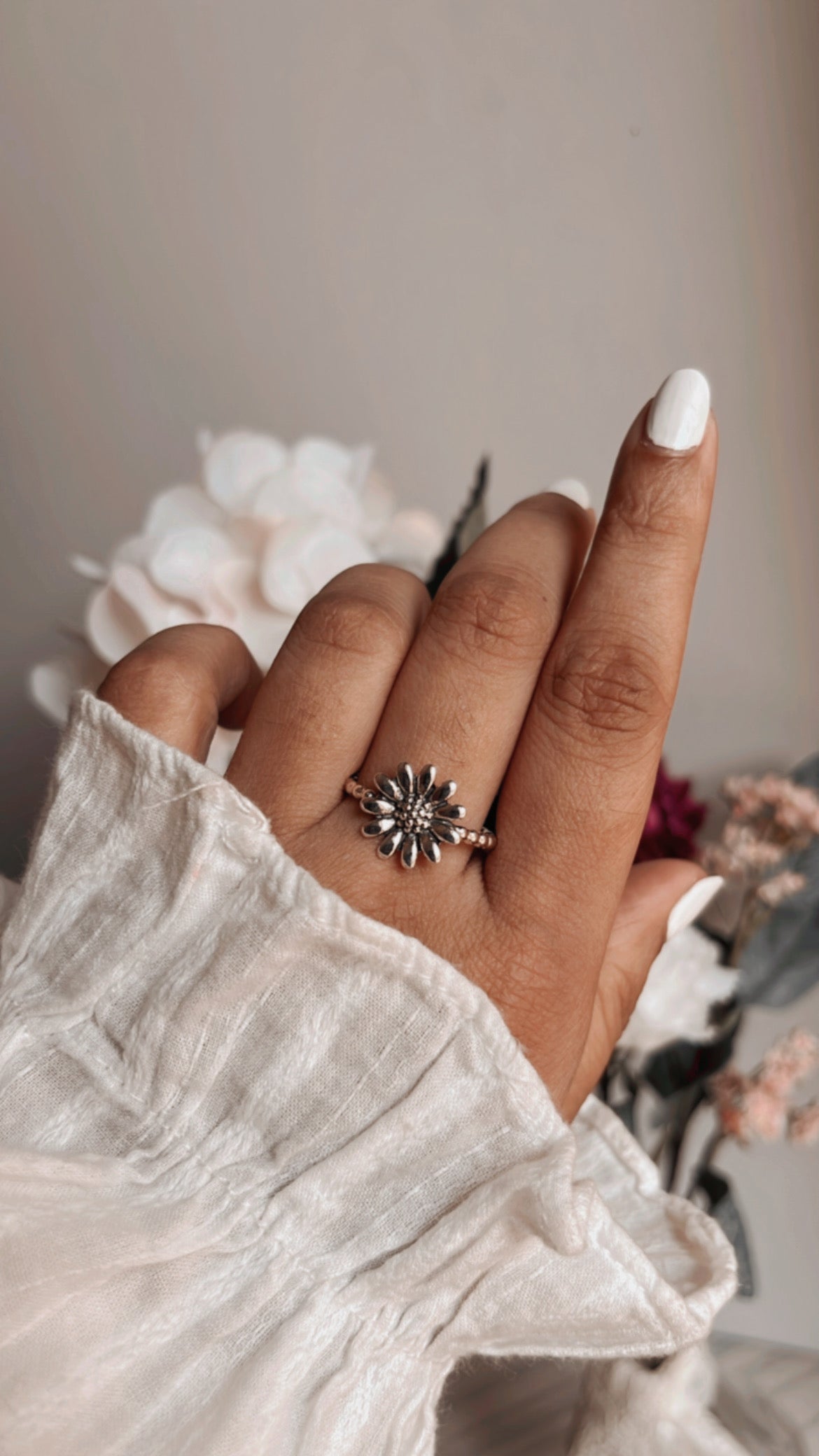 Close-up of daisy silver ring with detailed petals