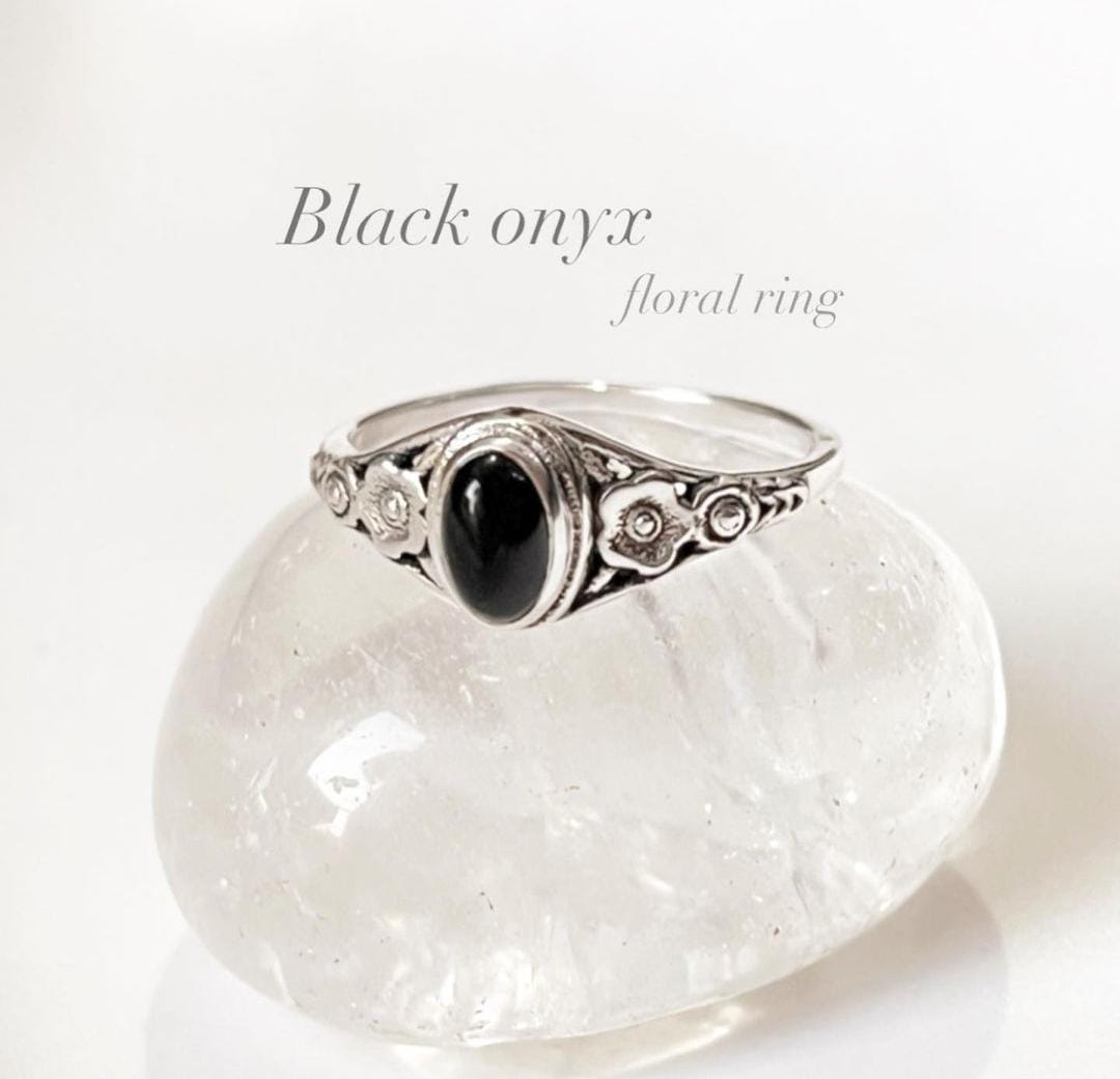 Elegant black onyx flower silver ring with intricate petal design.