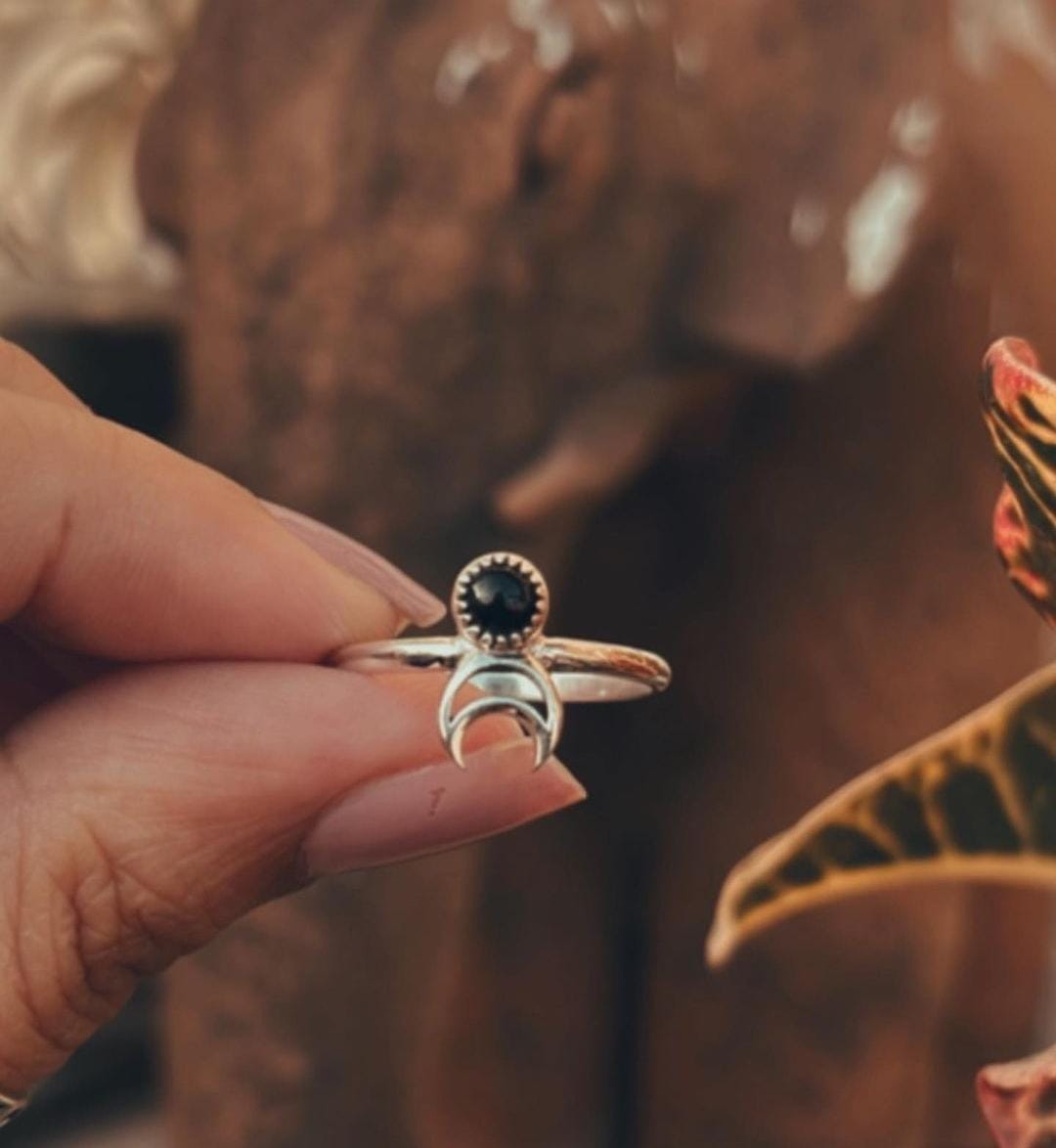 Charming silver ring featuring a black onyx crescent moon design.