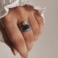 Garnet gemstone set in a silver ring with a leaf-inspired wrap