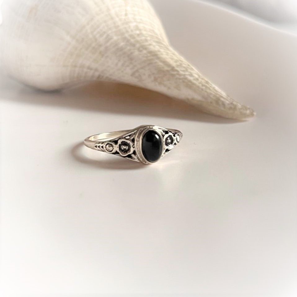 Sleek black onyx flower silver ring with delicate floral detailing.