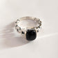 Modern black onyx Cuban link band silver ring with intricate design.