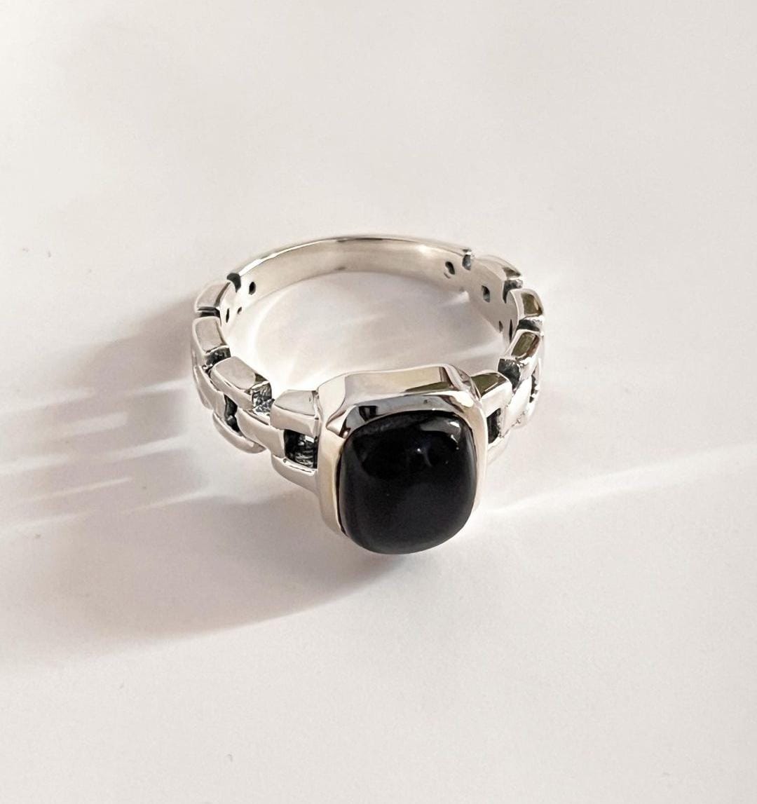 Modern black onyx Cuban link band silver ring with intricate design.