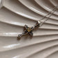 Close-up of citrine cross vintage pendant with ornate silver design