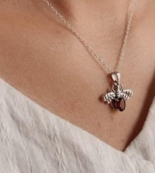 Timeless 925 sterling silver pendant featuring a bee motif and vibrant garnet stone.