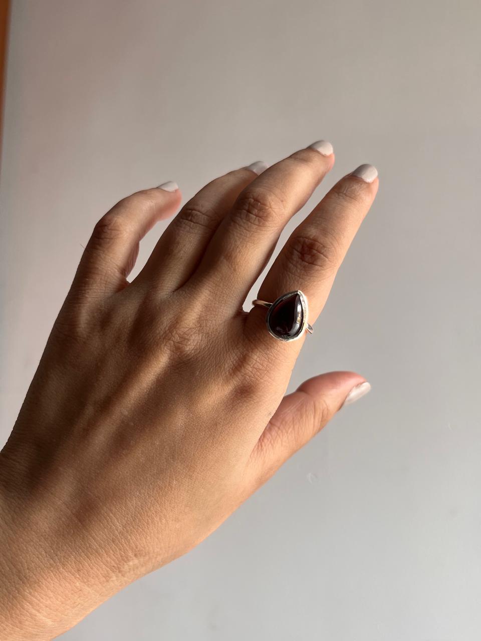 Big silver ring featuring a stunning pear-cut garnet stone