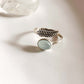 Adjustable silver ring featuring a feather design and aqua chalcedony stone.