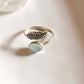 Sleek adjustable silver ring with a delicate feather design and aqua chalcedony gemstone.