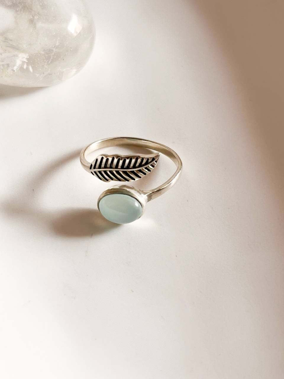 Sleek adjustable silver ring with a delicate feather design and aqua chalcedony gemstone.