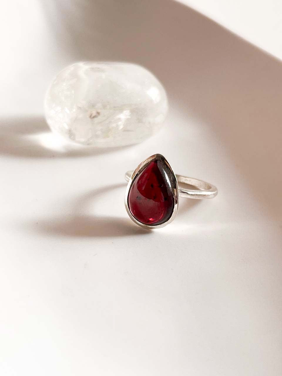 Garnet pear cut ring in a sleek plain silver design