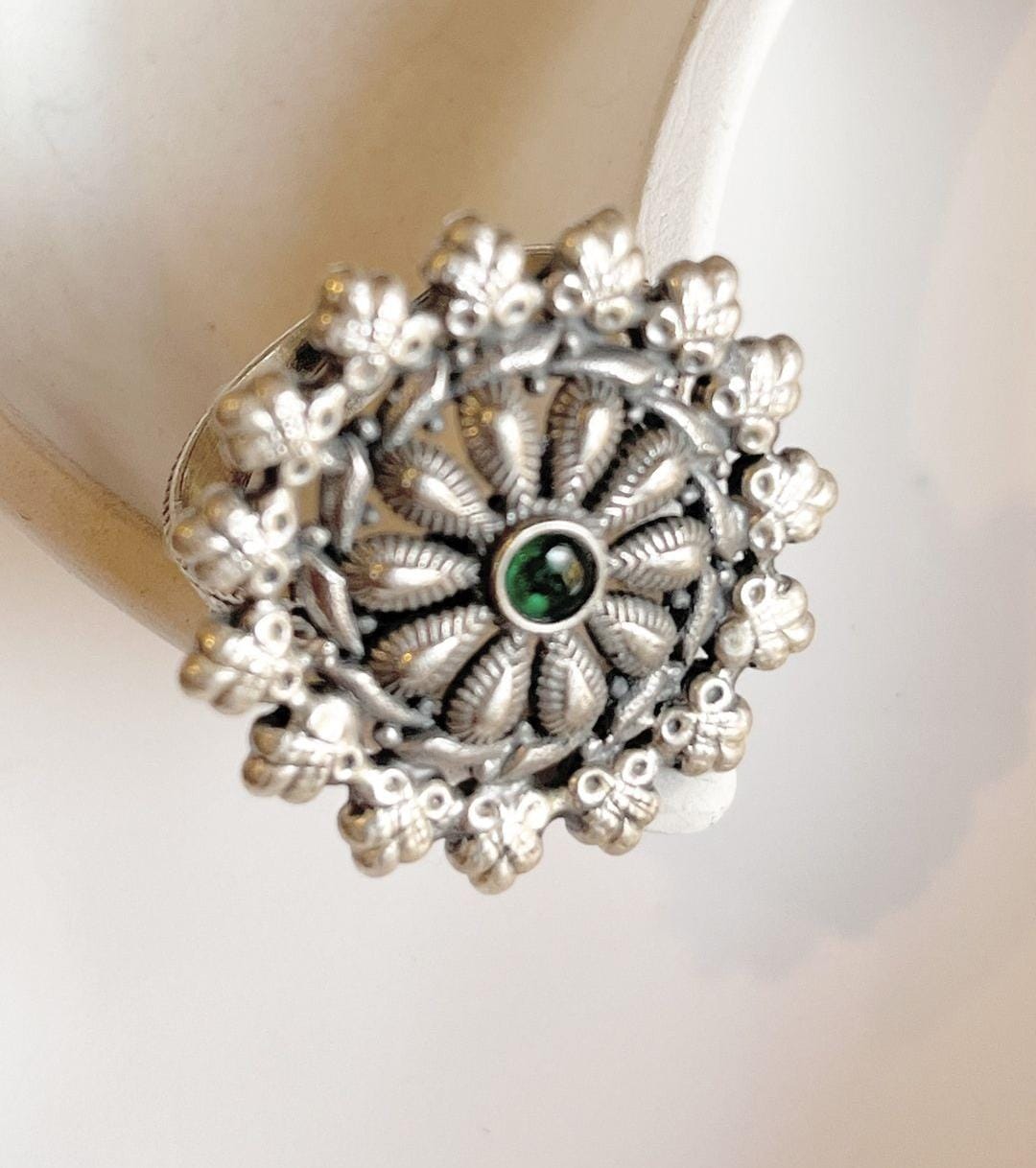 Intricate mandala-style statement ring in silver 925 with a green flower accent.