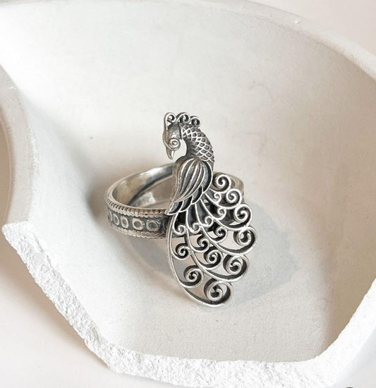 Handcrafted antique silver ring with intricate filigree and peacock design.