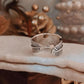 Close-up of feather wrap adjustable silver ring with a polished and smooth finish
