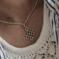 Sleek big karma pendant with Celtic knot details in sterling silver.