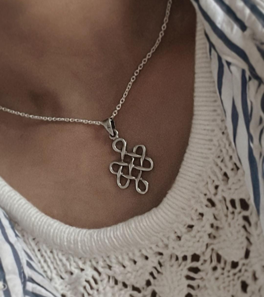Sleek big karma pendant with Celtic knot details in sterling silver.
