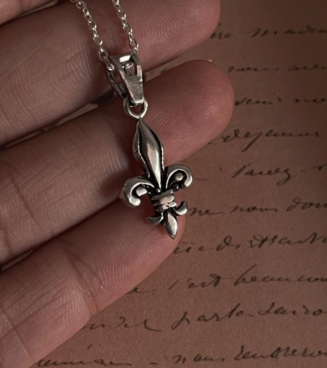 Charming Fleur De Lis silver pendant with a polished, shiny finish