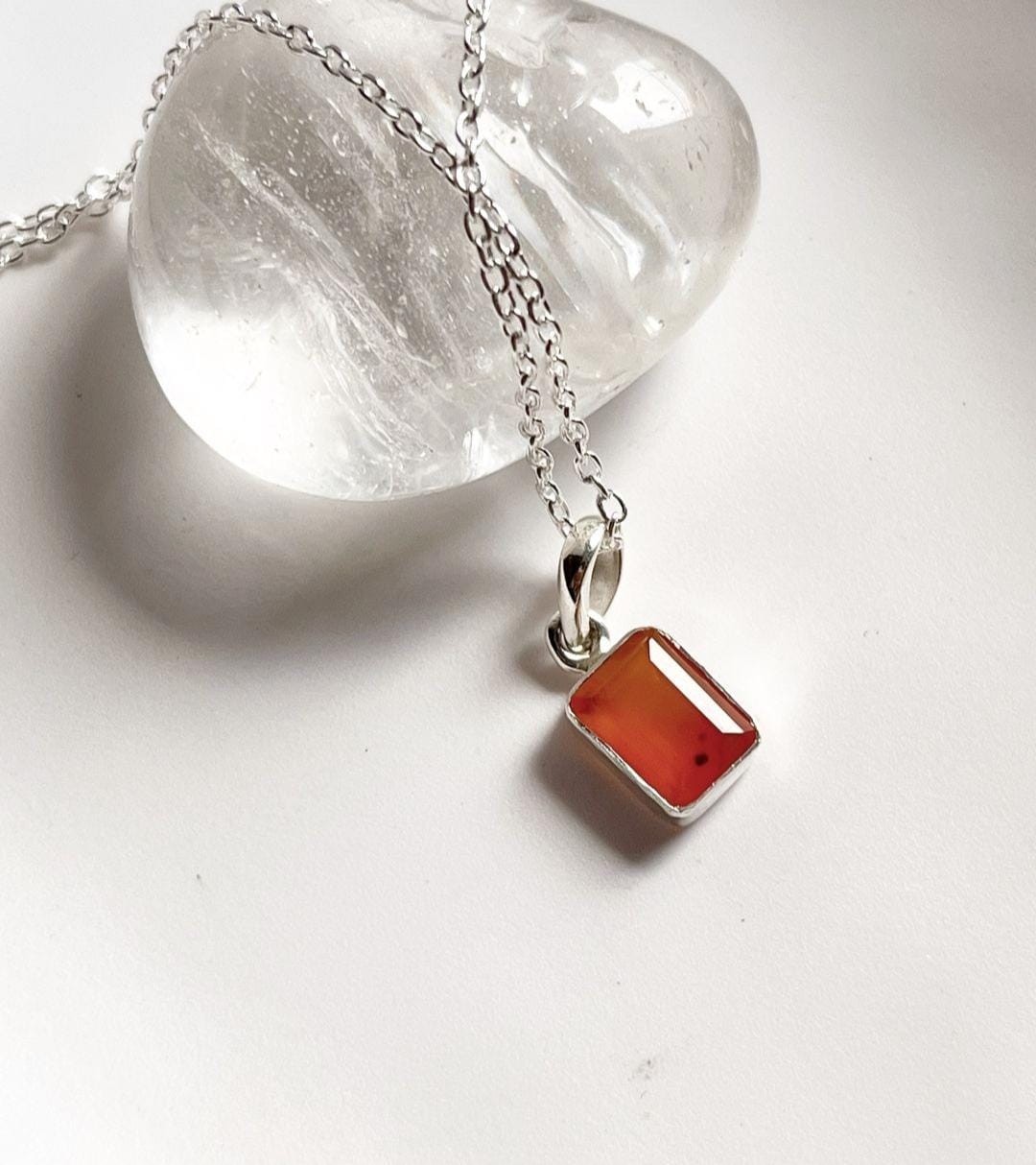 Close-up of carnelian rectangle pendant hanging from silver chain
