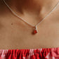 Close-up of carnelian round stone hanging from a silver pendant