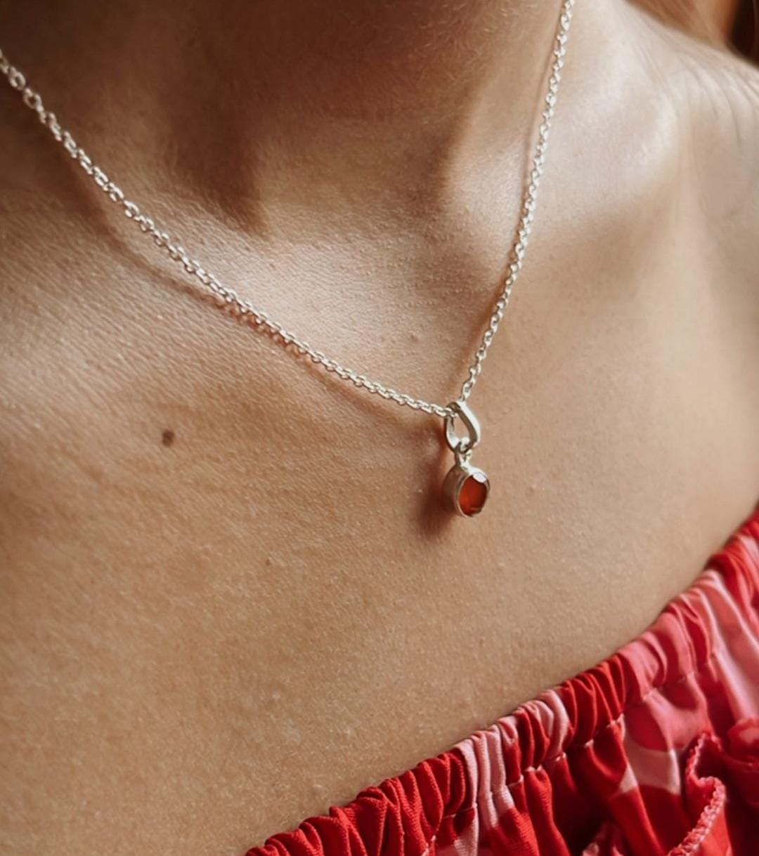 Smooth carnelian round pendant with simple silver design
