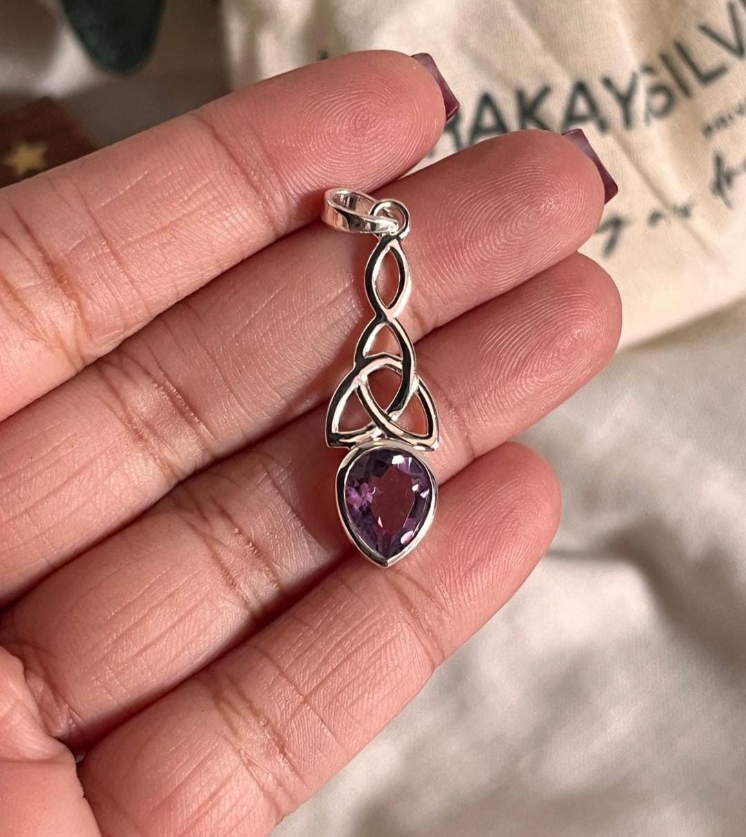 Elegant amethyst trinity knot pendant in sterling silver.