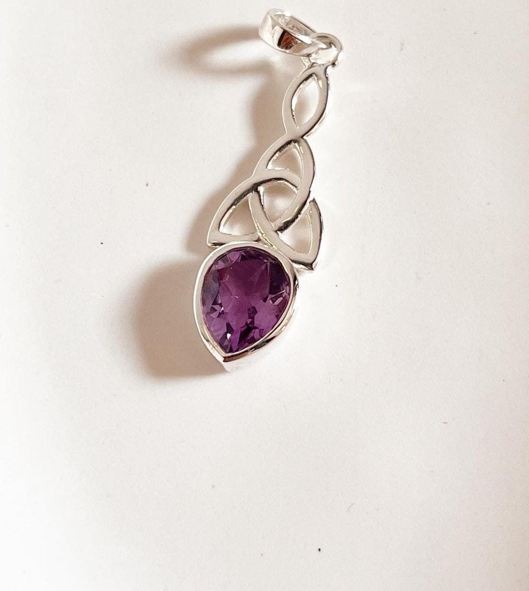 Sterling silver pendant with amethyst stone and trinity knot detail.
