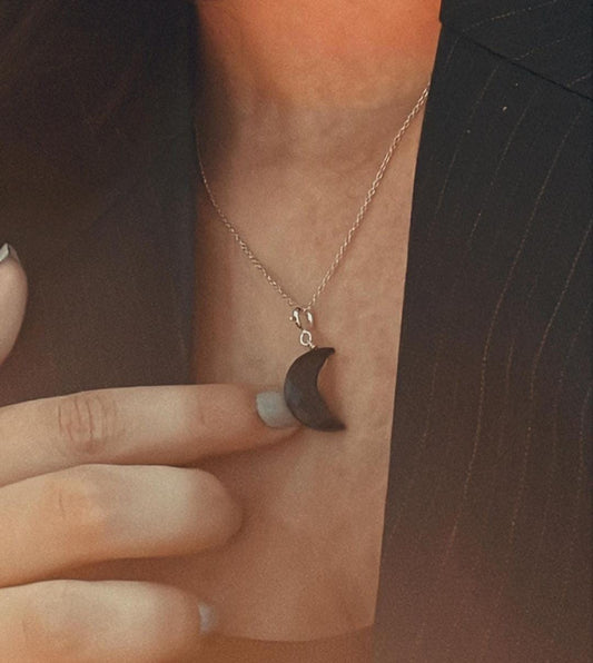 Sleek crescent moon charm featuring black onyx and crystal highlights.