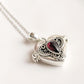 Silver pendant featuring a garnet heart design with hidden storage