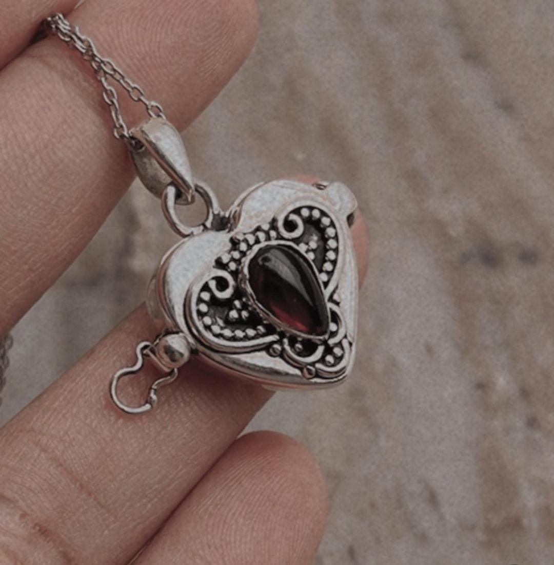 Vintage silver pendant with a garnet heart and concealed storage space