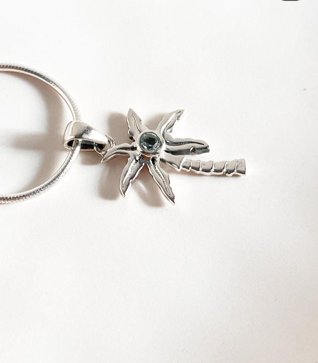 Elegant Blue Topaz Silver Pendant with Palm Tree Design