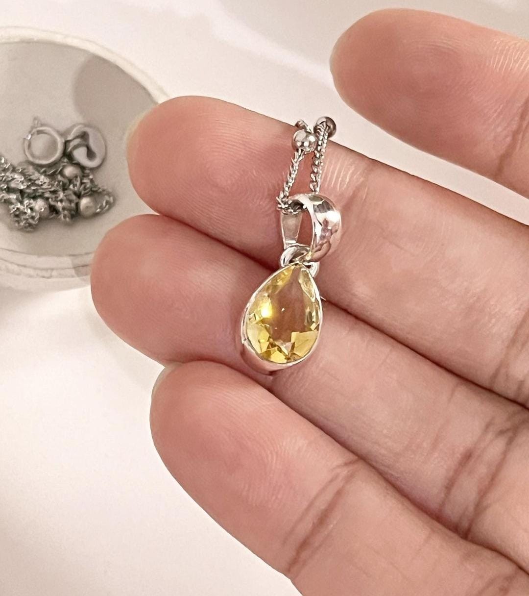 Close-up of citrine pear cut gemstone set in a silver pendant