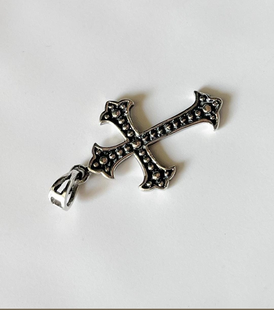 Close-up of cross silver pendant with intricate detailing