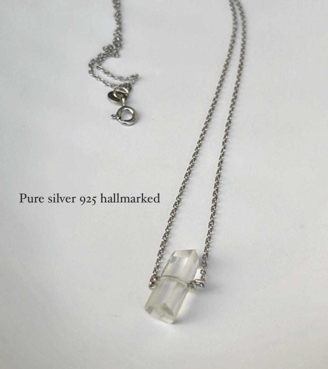 Close-up of clear quartz pencil crystal necklace with minimalist design