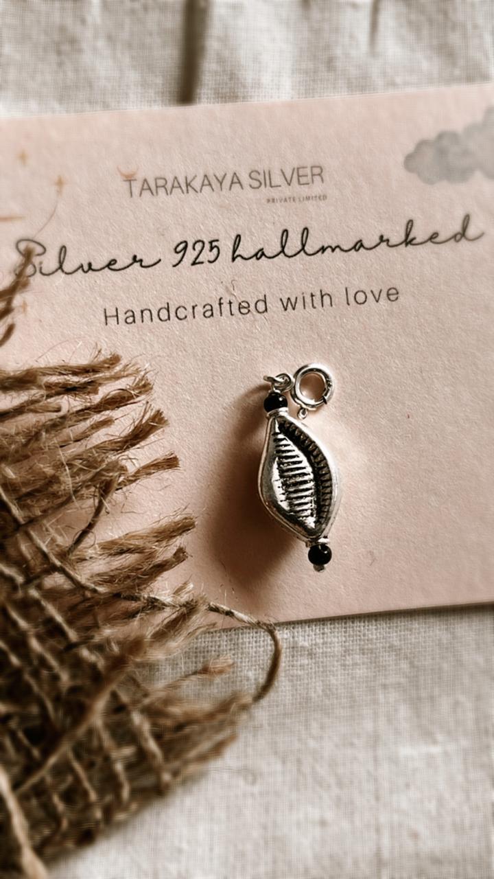 Close-up of cowrie shell charm in sterling silver pendant