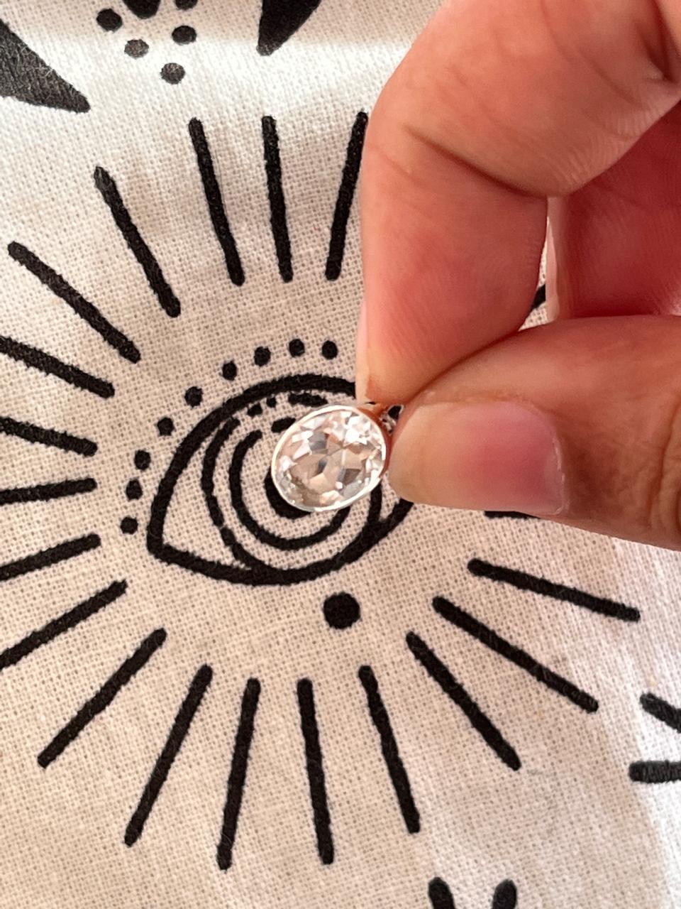Close-up of clear quartz oval cut pendant in polished silver setting