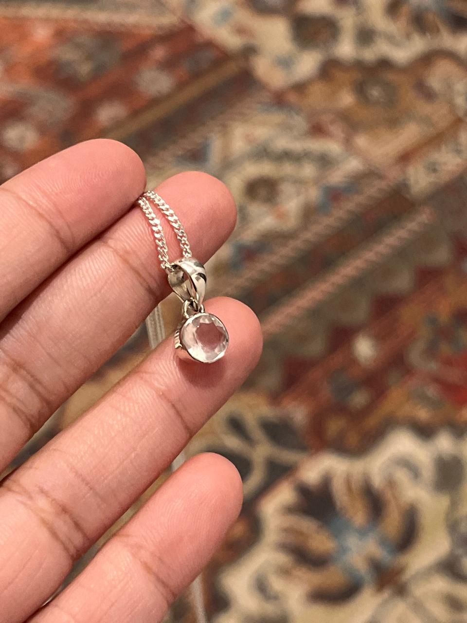 Handcrafted silver pendant featuring a round cut clear quartz gemstone