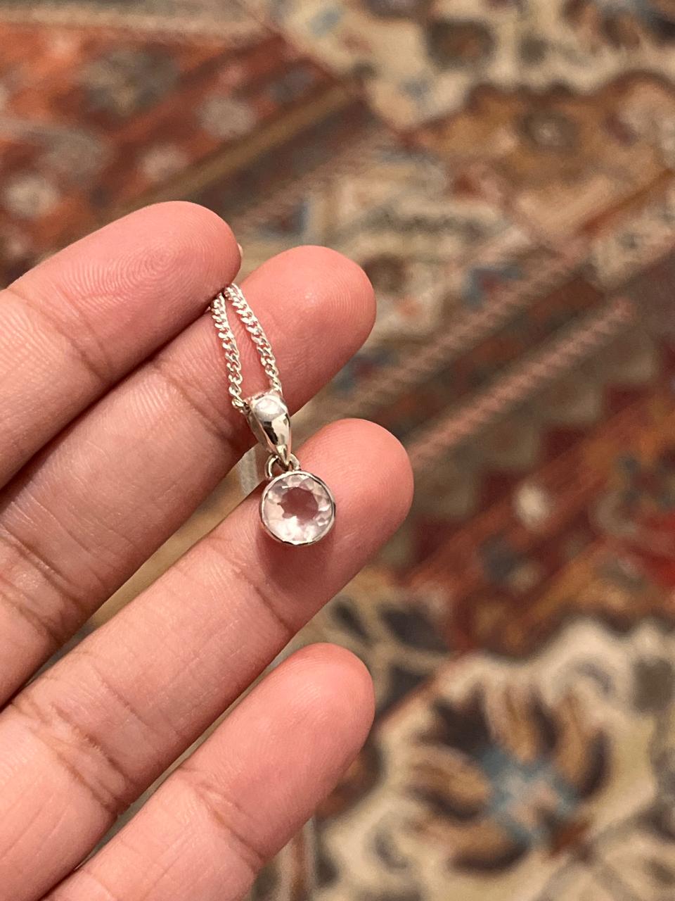 Sleek round cut clear quartz stone set in a silver pendant