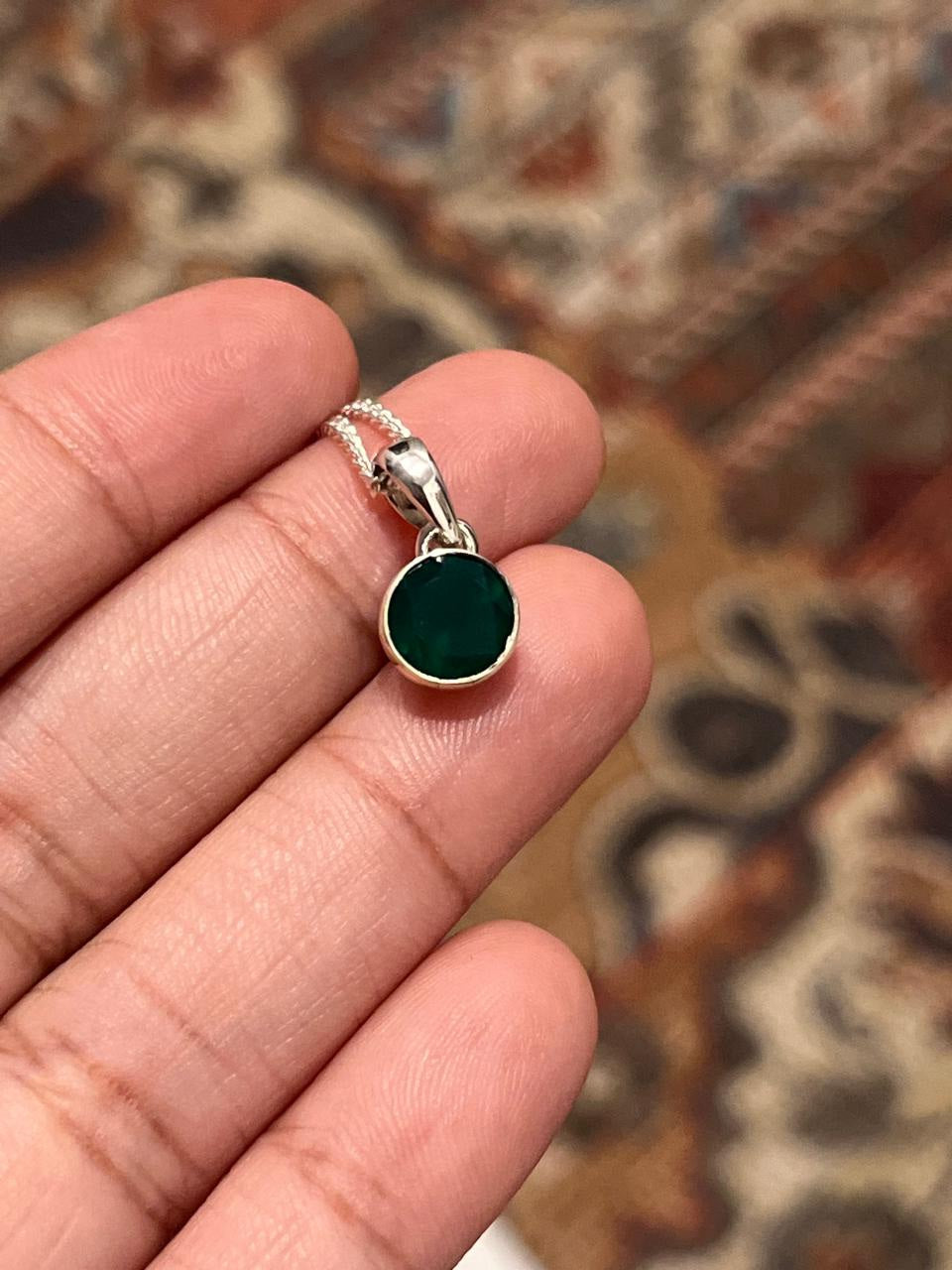 Sleek round cut green onyx pendant with a polished silver setting
