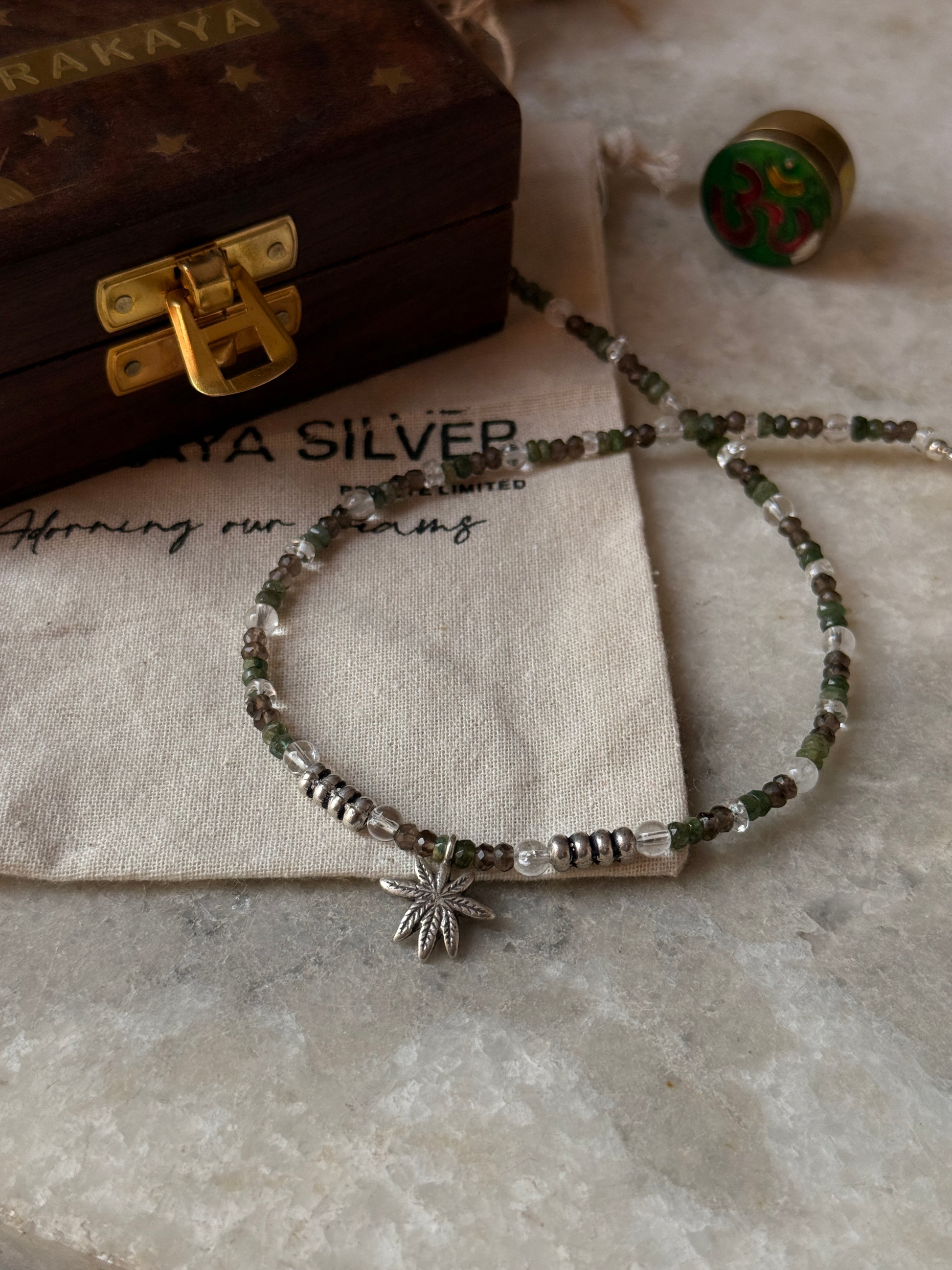 Artisan 925 sterling silver necklace featuring smokey quartz, emerald, and marijuana charm