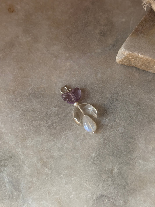925 Sterling Silver Amethyst, Clear Quartz Moon & Moonstone Charm on a stone surface.